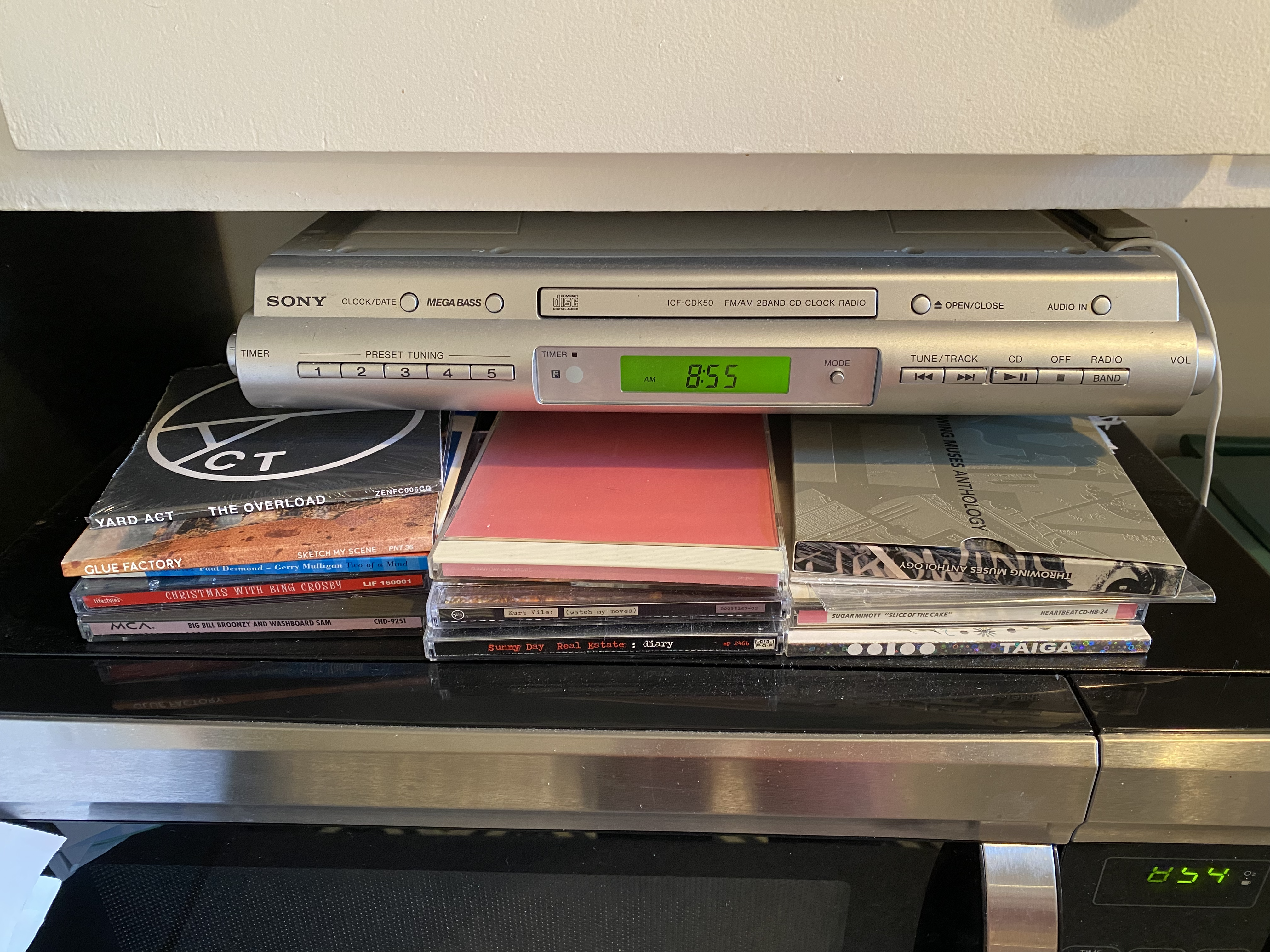 Small stacks of cds atop a microwave
